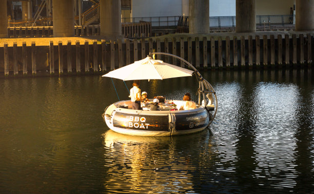 人们在金丝雀码头的野餐船上欣赏日落图片下载