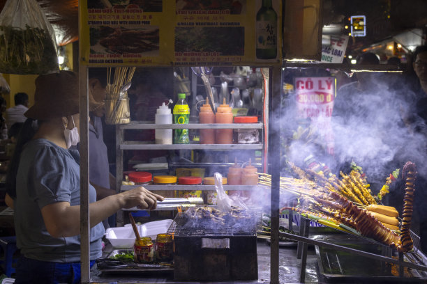 在夜市卖街头小吃的越南小贩图片下载