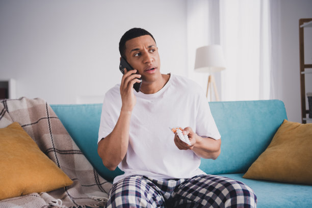 沮丧悲伤的家伙的照片，睡衣，睡衣，休息，沙发，谈话医生，现代小工具，室内，房间，家，房子图片下载