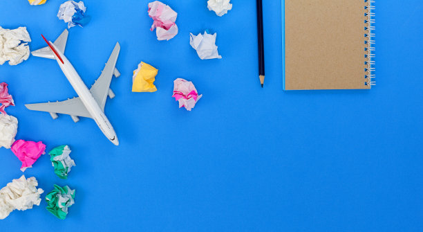 正上方的照片是皱巴巴的纸、模型飞机和蓝色背景上的书图片下载