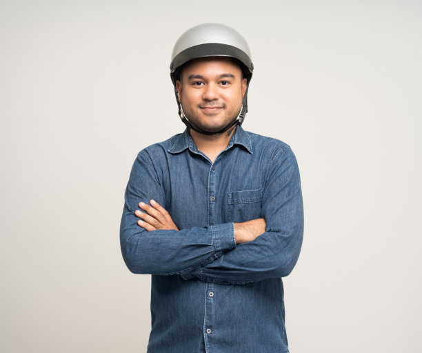 年轻骑手男子在骑摩托车前戴着安全帽。安全的旅程。图片下载