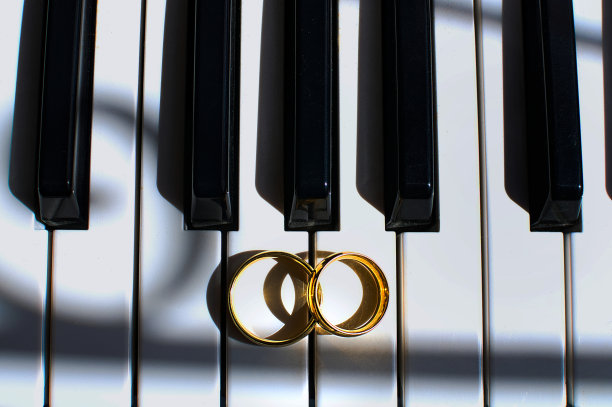 结婚戒指放在钢琴键上。求婚概念图片下载