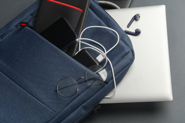 笔记本电脑与现代的小工具和配件，为工作和学习的背包在深灰色背景。图片下载