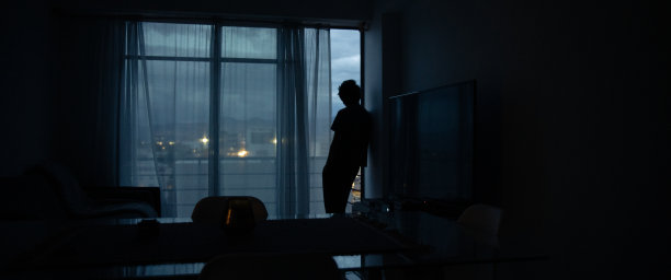 侧视图剪影男子站在窗户在家里图片下载