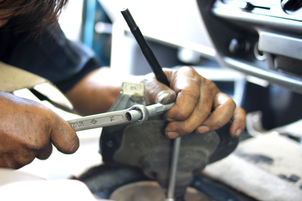 一个机械师正在修理汽车变速器。这张照片显示的只是手工修理。图片下载