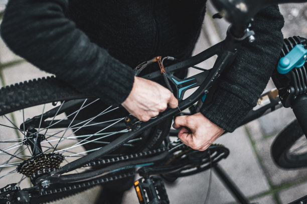 一个年轻人正在房子的后院里修自行车。图片下载