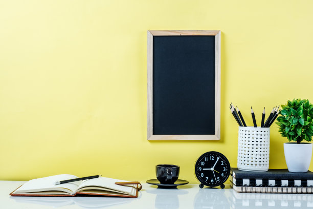 黄色背景下办公桌上的办公用品图片下载