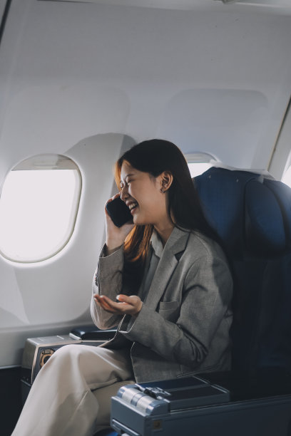 亚洲女人坐在飞机上的座位上，看着窗外的旅行度假旅行的概念。用这张令人惊叹的照片捕捉旅行癖的诱惑图片下载