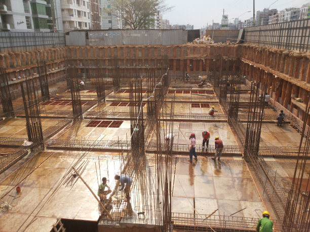 2024年8月2日，孟加拉国达卡。这张照片显示了一个建筑工地，工人们正在建造一个建筑物。场地被脚手架包围，可见许多水泥结构。图片下载