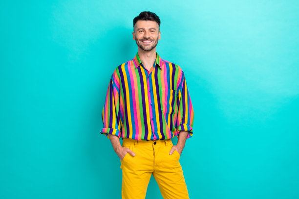 年轻的商人怪胎的照片，他把手放在口袋里，穿着时髦的老式条纹衬衫，在海蓝宝石的背景下享受他的服装图片下载
