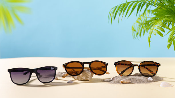在棕榈叶的海滩上，不同设计的时髦太阳镜。文本的复制空间。太阳镜销售概念。光学商店促销提供横幅。夏季眼镜时尚图片下载