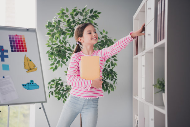 照片肖像可爱的小女生偷看书籍图书馆有趣的阅读书架家庭教育学校内部图片下载