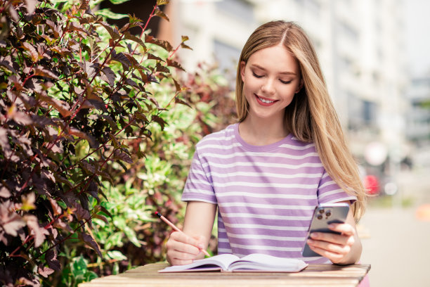 积极的好心情的女孩穿着紫色t恤坐在咖啡馆交流现代小工具户外城市城镇的照片图片下载