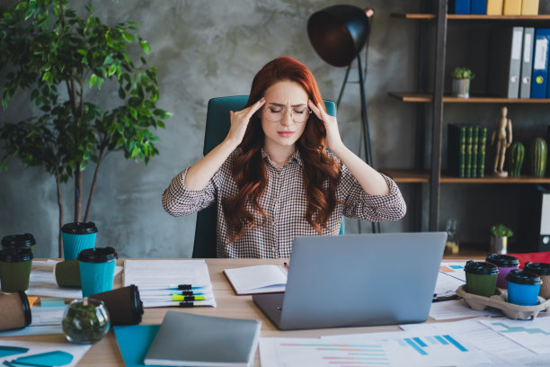 迷人的压力女ceo穿着正装衬衫的照片，感觉头痛，在工作场所、工作站、阁楼的室内打字图片下载