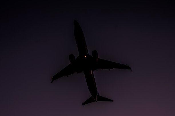 一架飞机在夜晚的天空中飞行图片下载