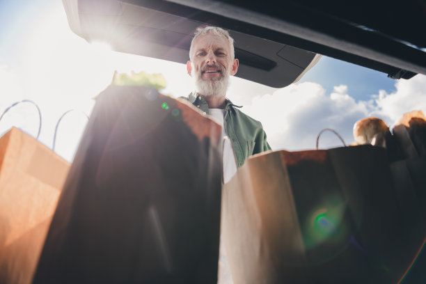 时髦酷的成熟男人穿着休闲衬衫的照片，准备好自动送你到城市街道外的杂货店购物图片下载