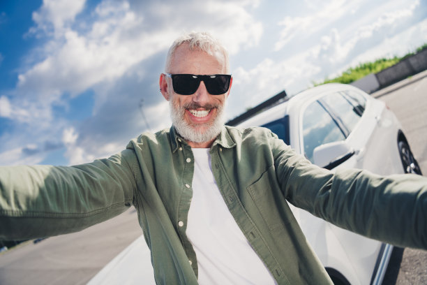 穿着卡其布衬衫的开朗积极的人在城市街道外选择车辆录制视频的照片图片下载