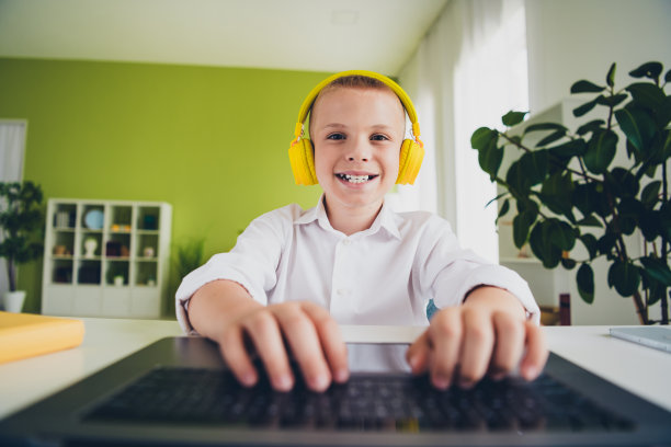 照片肖像小可爱的儿子小学生耳机在线课程远程教育家庭学校隔离室内背景图片下载