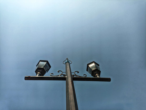 多云天空背景上的花园灯。花园灯光的低角度照片图片下载