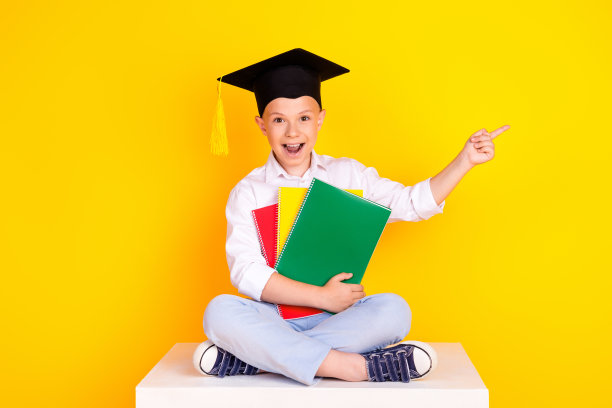 照片开朗快乐的好男孩毕业戴帽推荐空白空间孤立在黄色背景图片下载