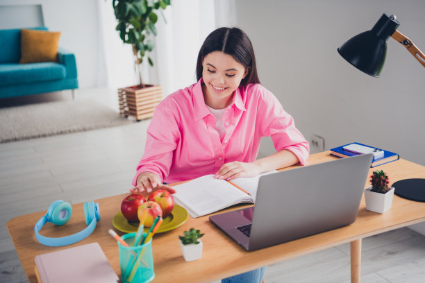 可爱的可爱的女士穿着粉红色的衬衫准备课程现代小工具吃苹果在室内房间家里房子的照片图片下载