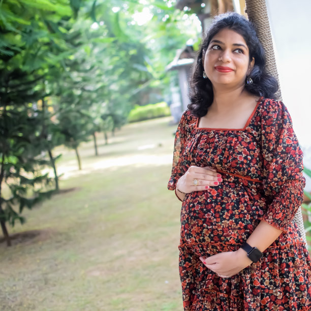 一名怀孕的印度妇女在户外拍摄怀孕照片，手放在肚子上，印度孕妇在社会公园穿着孕妇装把手放在肚子上，怀孕的孕妇在户外拍摄图片下载