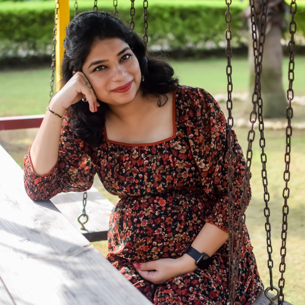 一名怀孕的印度妇女在户外拍摄怀孕照片，手放在肚子上，印度孕妇在社会公园穿着孕妇装把手放在肚子上，怀孕的孕妇在户外拍摄图片下载