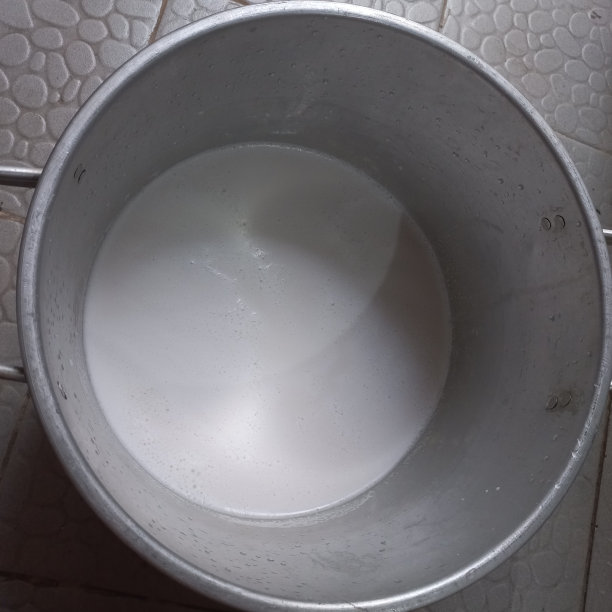 椰奶是手工煮米饭的新鲜原料，从成熟的椰子中提取的白色液体和水图片下载