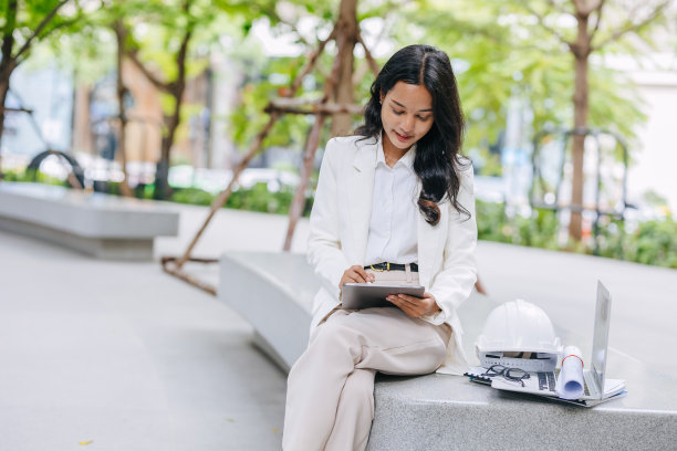 聪明的年轻工程师在绿色公园自然中使用平板草图设计。环保节能工程设计职业女性。图片下载