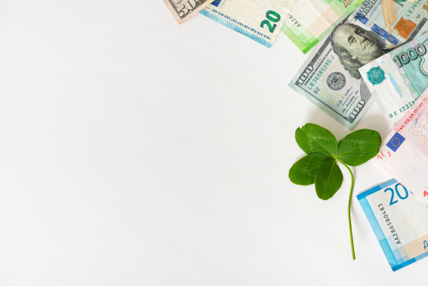 钱和三叶草。四叶三叶草在欧元，美元和卢布纸币的白色背景。财富、成功、事业、幸运、投资、赢、头奖的概念。幸运的护身符。副本的空间。图片下载