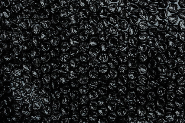 保鲜膜表面有黑色气泡纹理。表面带有气球的塑料用于包装易碎物品或电子物品或敏感物品图片下载