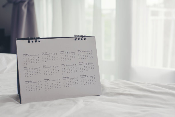日历台放在商务桌上。桌面日历规划师计划议程，时间表，约会，组织，管理每个日期，月，年在办公室的桌子上。日历2024概念。图片下载