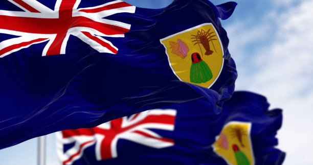 在一个晴朗的日子里，特克斯和凯科斯群岛的旗帜在风中飘扬图片下载