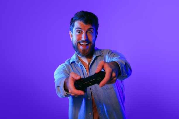 兴奋的玩家玩在线游戏，手持手柄控制器，工作室图片下载