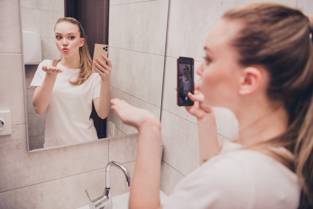 照片闪亮可爱的女孩睡衣会说话的镜子自拍现代设备发送亲吻自己在室内房子公寓洗手间图片下载