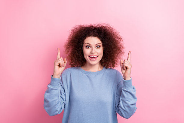 美丽的女孩穿蓝色运动衫的照片直接手指疯狂的主张廉价的黑色星期五孤立在粉红色的背景图片下载