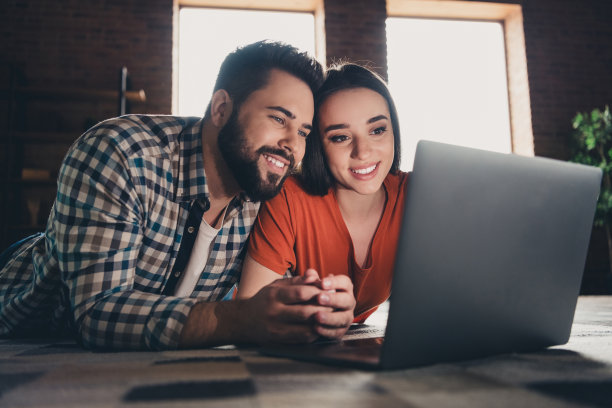 迷人的照片时髦的开朗躺在地板上网本已婚的年轻夫妇花空闲时间搬新公寓，家室内室内图片下载