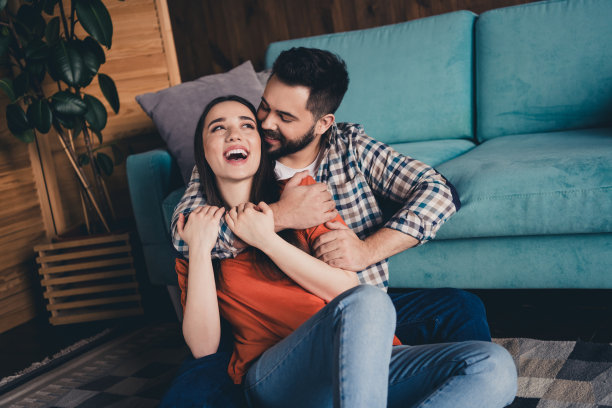 迷人的照片愉快地坐在地板上拥抱有乐趣已婚的年轻夫妇花空闲时间搬新公寓，家室内室内图片下载