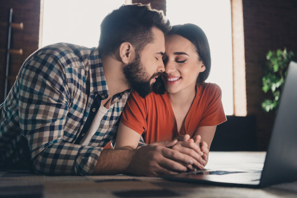 年轻夫妇躺在地板上上网本温柔的照片移动新的地方享受住在一起有乐趣的新公寓房间，灯的房子，公寓，室内图片下载