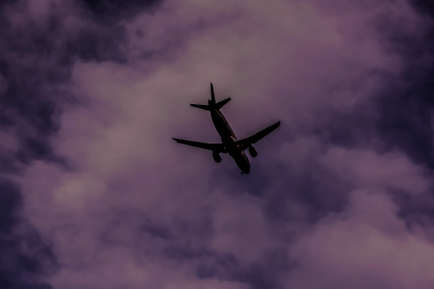 一架飞机在多云的天空中飞行图片下载