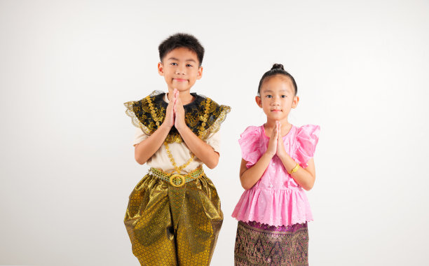 肖像泰国儿童男孩和女孩微笑着传统的泰国服装在工作室孤立的白色背景下摆姿势致敬，快乐的小学和幼儿园的孩子们看到了象征图片下载