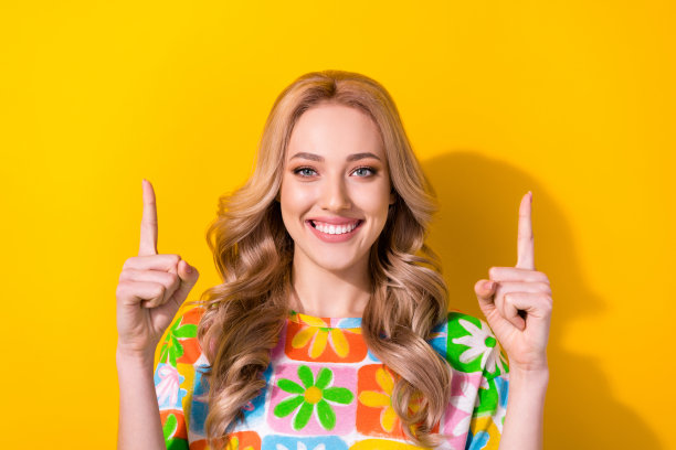 照片中年轻女士的肖像直接手指向上空的空间横幅海报穿夏天印花衬衫孤立的黄色背景图片下载