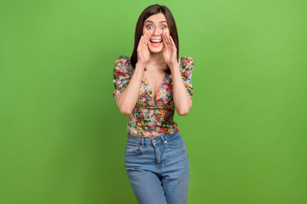 年轻的兴奋时髦的女孩的照片穿着时髦的印花花朵装饰衬衫宣布大的夏季销售孤立的绿色背景图片下载