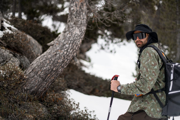 戴着眼镜和宽帽的滑雪者侧过身来看着镜头图片下载