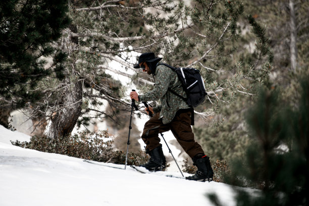一个年轻的滑雪者自信地滑下斜坡，勤奋地重新安排他的滑雪杖图片下载