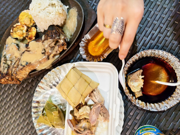 一顿美味的饭有烤金枪鱼下巴，奶酪烤扇贝，乳香婴儿，和大米。这张照片拍摄于一个美食广场，突出了菲律宾美食。图片下载