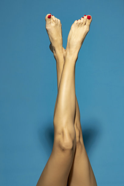 裁剪的图片查看照片好看的长可爱的有吸引力的适合瘦苗条柔软光滑修剪干净剃光腿在蓝色的工作室背景。图片下载