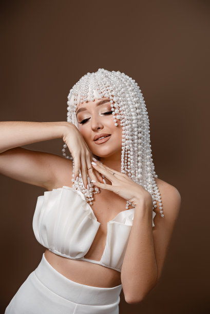 时尚的照片，一个美丽优雅的年轻女子在一个漂亮的西装摆姿势在黑暗的背景。时尚照片。魅力模特，工作室拍摄。美。奢侈品图片下载