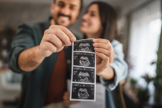 夫妇手握婴儿的超声波照片的特写图片下载