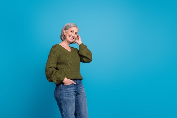 照片可爱的祖母女人灰色的头发，抚摸她的头发，穿着时尚的休闲服装，学院风格的购物广告孤立的蓝色背景图片下载